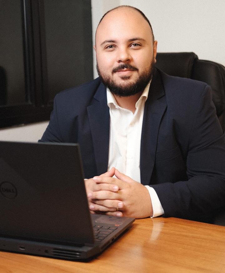 Lucas André Silva, advogado, sentado à mesa do escritório